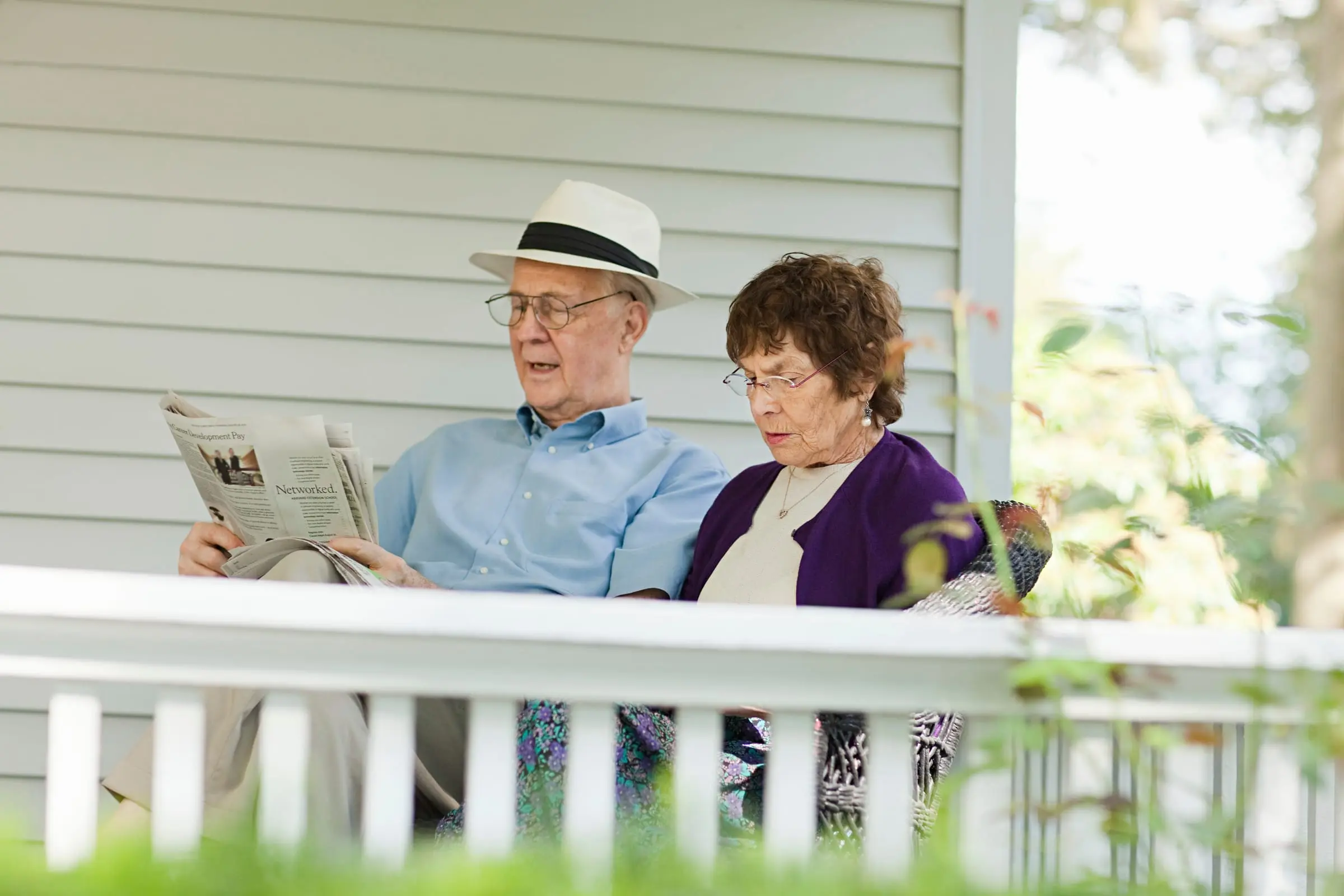 An older couple relaxing on their front porch