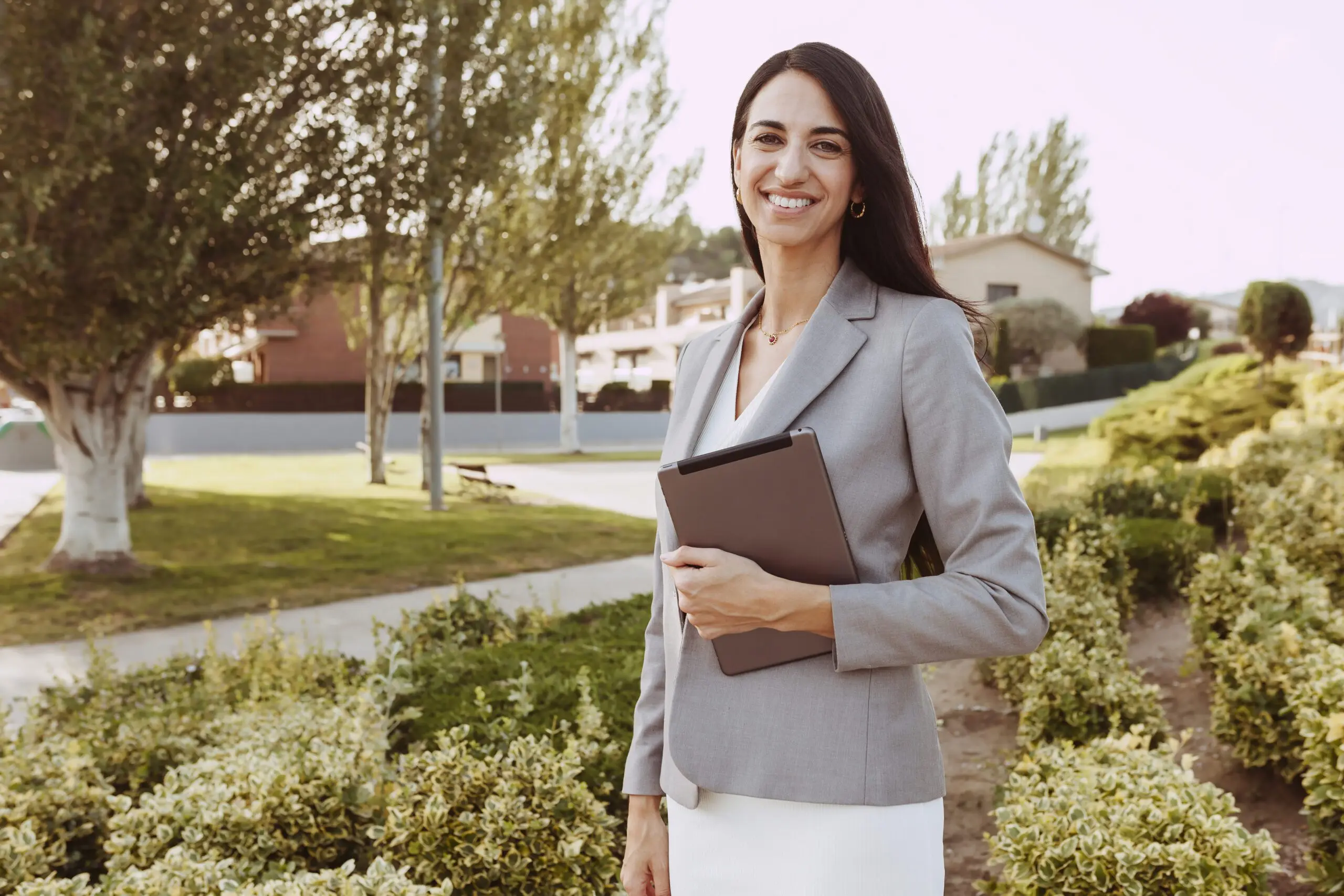 Urban happy business woman holding and using tablet computer and